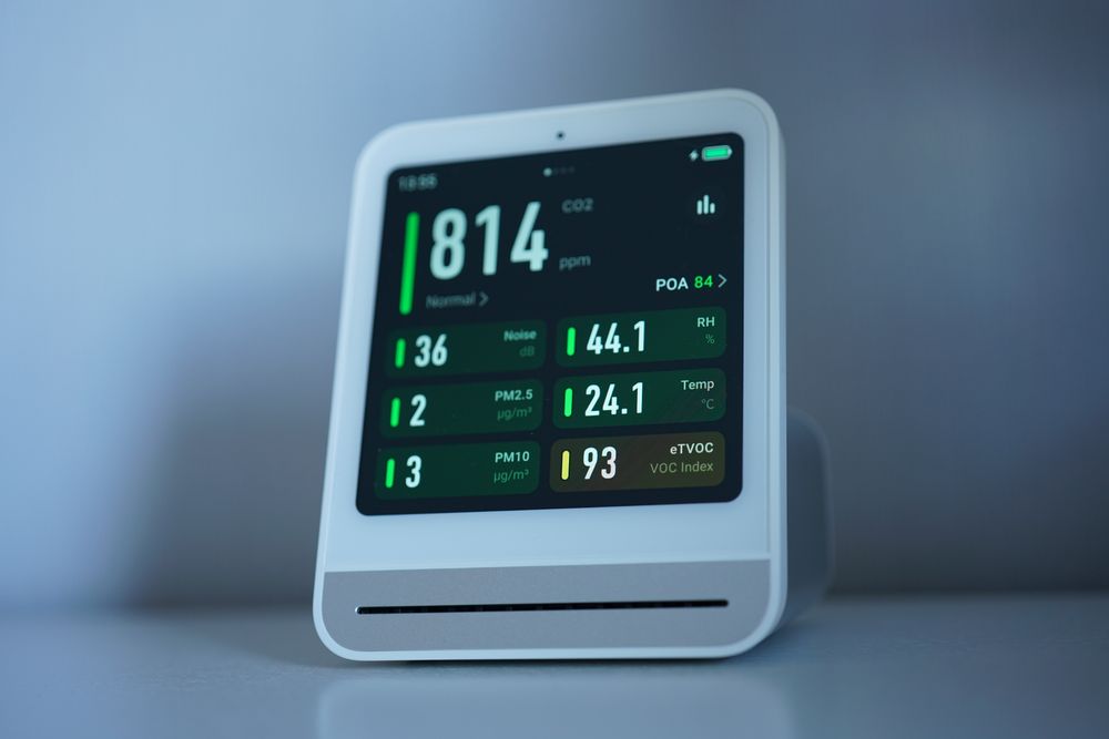 Indoor air quality monitor showing CO2 and particle readings